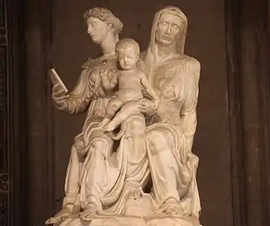 Statue. Groupe représentant une femme sur le genou d'une autre et tenant un bébé dans les bras.