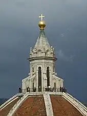 Photographie d'une coupole d'un édifice religieux avec des visiteurs à sa base et surmontée d'une boule avec une croix.