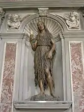 Statue en bois d'une femme âgée faisant pénitence