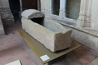 Sarcophage en pierre posé sur un chevalet d'exposition dans une église.