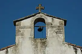 Photographie d’un clocher-mur sur fond de ciel d’azur.