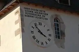 Photographie d’une horloge murale avec une inscription en basque.