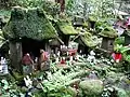 Petites statues d'Inari et sanctuaires miniatures couverts de mousse.