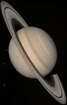 Image Saturne avec des anneaux obliques. Les lunes sont des points brillants.