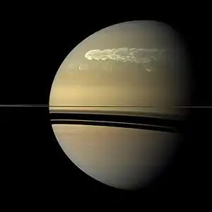 Un ensemble de nuages clairs présent à la surface de Saturne sur un fond plus sombre, formant une grande tache blanche.