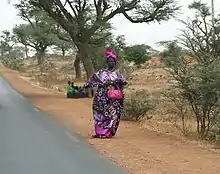 femme pointant à l'aide de son doigt au bord d'une route