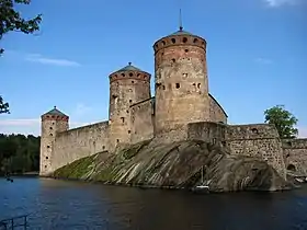 Photographie en couleurs d'une forteresse entourée de douves.