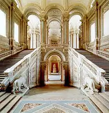 Photo d'un grand double escalier à l’intérieur d'un palais richement décorée.