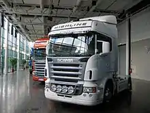 Deux poids lourds Scania exposés en concession ou en sortie d'usine.