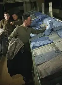 En 1944, dans un centre de démobilisation au Royaume-Uni, un militaire fait son choix parmi des chemises civiles.