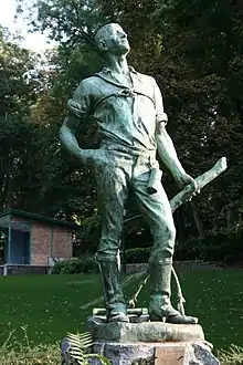 Statue de bronze d'un élagueur avec un étui cylindrique fixé à sa ceinture et tenant à la main une branche coupée.