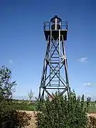 Photographie en couleurs d'un phare entouré par des végétations