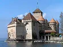 Photographie en couleurs représentant un château-fort dont la base des murailles baigne dans l'eau.