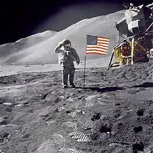 Photographie en couleur d'Irwin saluant le drapeau américain planté sur la Lune.