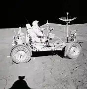 Photographie en couleur de Scott conduisant le rover lunaire.