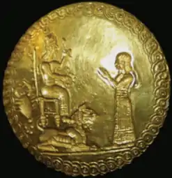 Sceau en or de la reine Hama (antichambre de la tombe III, sarcophage n°2), la représentant devant une divinité (Gula ?). Le scorpion représenté à gauche est un symbole des reines assyriennes. Musée national d'Irak.