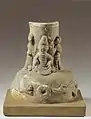 Socle d'un "arbre à sapèques" avec le Buddha assis. Dynastie des Han de l'Est, 2e siècle. Mis au jour au Sichuan. Céramique à glaçure brunâtre. H. 21,3 cm. Musée de Nankin