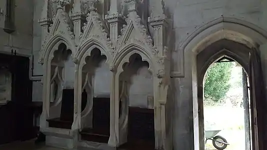 Niches de style gothique flamboyant dans le mur d'une église.