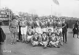 Un groupe de sportifs pose pour une photographie en noir-et-blanc.