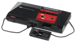 Console de jeu vidéo, boite rectangulaire noire et rouge équipée d'un fil et dune manette de jeu.