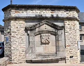 Ancienne fontaine avec le blason de la commune sculpté.