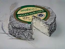 Vue d'un fromage cendré à croute molle blanche.