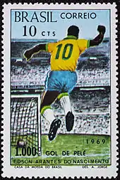 Timbre en couleurs d'une valeur de dix centimes représentant un joueur de football du Brésil avec le numéro 10, de dos, sautant de choix. Le chiffre 1000 est représenté en bas à gauche du timbre.