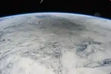 Vue depuis la Station spatiale internationale d'une large zone sombre au-dessus du Pacifique et de sa couverture nuageuse.