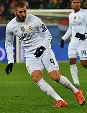 Photo de Karim Benzema en plein pied en train d'effectuer une course d'appel sur un terrain de football avec le maillot du Real Madrid