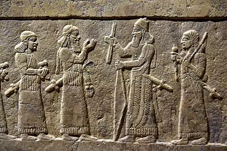 Bas-relief de l'estrade de la salle du trône de Fort-Salmanazar, face sud : Salmanazar III reçoit le tribut du chaldéen Musallim-Marduk du Bit-Amukkani. Musée national d'Irak.
