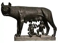Statue sombre de Romulus et Rémus, enfants, qui se dressent, nus, pour se nourrir aux pis de la louve