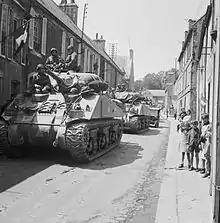 Chars M4 Sherman et Jeep du 30e corps d'armée britannique traversant Bayeux en 1944, pendant la bataille de Normandie.