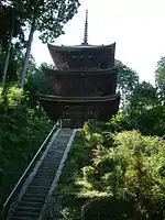 Pagode en bois à deux étages au sommet d'un long escalier.