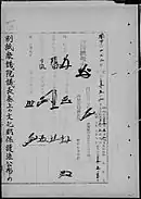 Photo noir et blanc de signatures sur une page d'un texte de loi écrit en japonais, noir sur fond blanc.