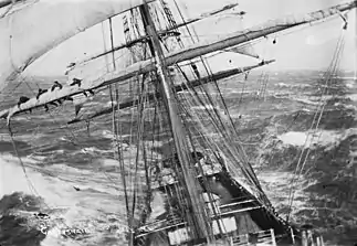A bord du Garthsnaid accrochant une voile sur une mer agité en 1920.