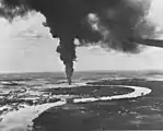 Navires et installations en feu sur le front de mer de Saïgon après une attaque aérienne par des avions de la flotte américaine du Pacifique, le 12 janvier 1945.