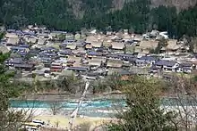 Photo couleur d'un cours d'eau traversant un village.