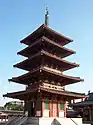 Photo couleur d'une pagode en bois à cinq étages sous un ciel bleu.