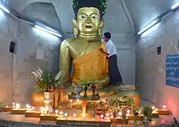 Croyant collant une feuille d'or sur la statue principale du Bouddha du Temple.