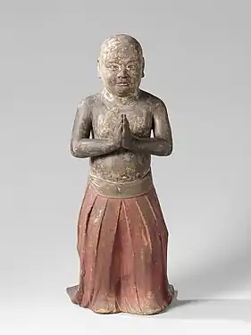 Shōtoku enfant, debout, les mains jointes en signe d'adoration. Il porte une robe rouge plissée, entre 1200 et 1350, bois sculpté peint, 74,5 × 32 × 40 cm, Rijksmuseum Amsterdam, Pays-Bas.