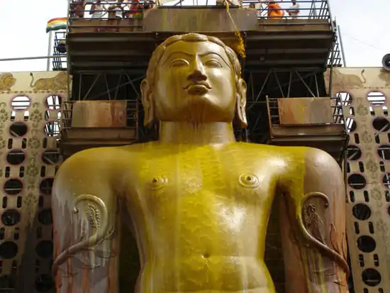 Statue de Gomateshvara recouverte par les offrandes