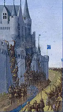 Miniature montrant une armée de soldats en armure prenant d'assaut une ville fortifiée.
