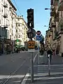 Image représentant un feu tricolore de tramway avec la barre verticale marquant le passage autorisé allumée, ainsi que la vitesse limitée à 30 km/h à la station Palais des expositions.