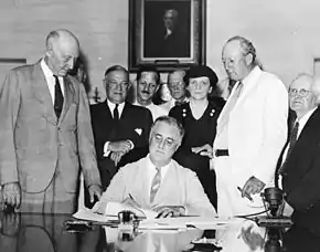 Frances Perkins à la signature par le président Franklin Roosevelt de la création d'une sécurité sociale.