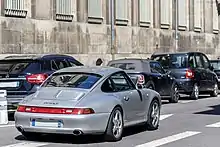 Carrera S de couleur grise photographiée de 3/4 arrière dans la rue.