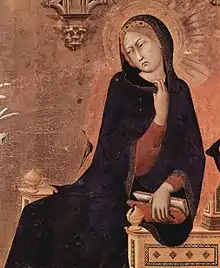 Détail de L'Annonciation (1333) de Simone Martin. La Vierge, enveloppée d'un long vêtement noir, est assise sur un siège sa main gauche posée sur l'accoudoir et l'index et le majeur de la main droite accrochés au col de son vêtement, la tête penchée vers la droite. Elle ne fixe pas l'apparition, mais paraît la méditer