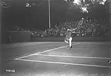 Photographie en noir et blanc d'une joueuse de tennis réalisant un coup droit sauté.