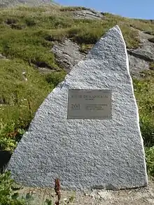 Pierre triangulaire portant une plaque commémorative.