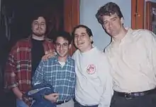 Photo de quatre hommes coupés à la taille.