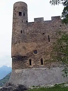 Petite tour arrondie dans l'angle d'un mur. Le fond de la tour se confond avec l'angle.